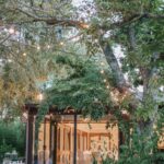 Soirée dans le parc du Clos des Eyssauts sous les guirlandes lumineuses, invités attablés