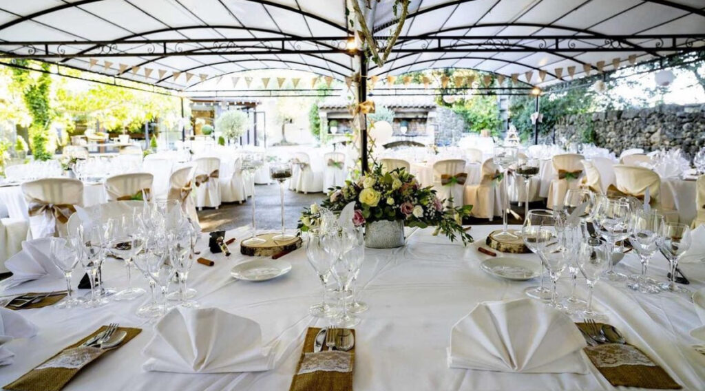 Tables dressées sous la tonnelle en fer forgé du Clos des Eyssauts